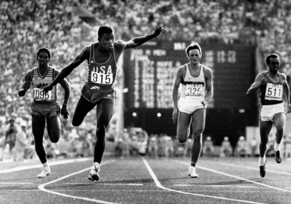 U.S. athlete Carl Lewis (915) flies over the finish line to win the 200-meter run of the Olympic Games at Memorial Coliseum in Los Angeles, Aug. 9, 1984.  From left to right:  Joao Batista of Brazil, Lewis, Ralf Luebke of West Germany and Pietro Mennea of Italy.  (AP Photo/Pool)